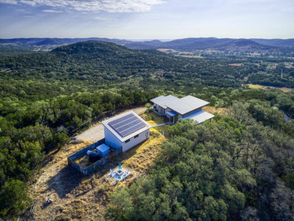Drone view: front of House. Hill Country Views. back of Solar Panels on Garage. 238 Hills of Bandera Rd